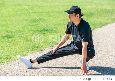 公園で準備体操・ウォーミングアップするスポーツウェアの男性 公園で準備体操・ウォーミングアップするスポーツウェアの男性 129942313