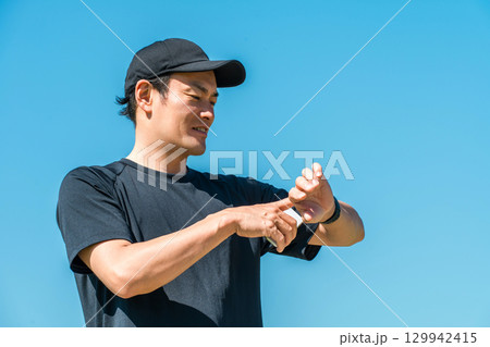 スマートウォッチ,万歩計,歩数計を使い健康管理・ヘルスケアをするスポーツウェア姿の中年男性 スマートウォッチ,万歩計,歩数計を使い健康管理・ヘルスケアをするスポーツウェア姿の中年男性 129942415