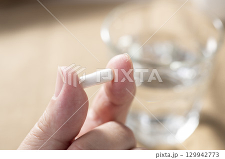カプセル剤を持つ男性の手 カプセル剤を持つ男性の手 129942773