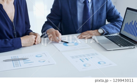 Business partners are discussing company performance and making plans based on charts and graphs displayed on laptop and printed documents. Businesspeople and finance Business partners are discussing company performance and making plans based on charts and graphs displayed on laptop and printed documents. Businesspeople and finance 129943011