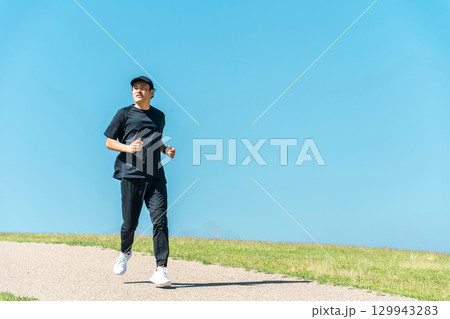 青空の下でランニング・ジョギングをする男性(アスリート・有酸素運動・ワークアウト・フィットネス) 青空の下でランニング・ジョギングをする男性(アスリート・有酸素運動・ワークアウト・フィットネス) 129943283