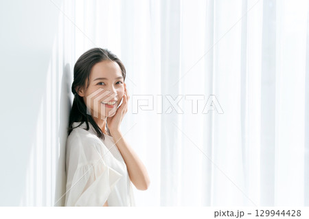 窓際に立つシャツの女性 129944428