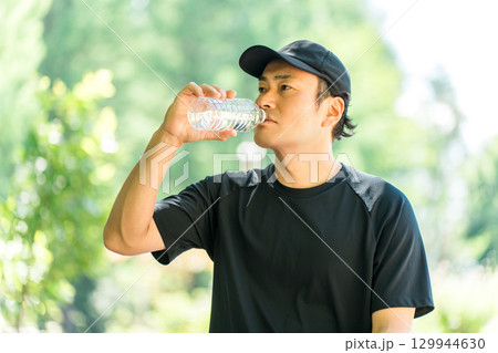 運動中に水・ミネラルウォーターを飲む男性(水分補給・運動・ワークアウト・ランニング・ウォーキング) 運動中に水・ミネラルウォーターを飲む男性(水分補給・運動・ワークアウト・ランニング・ウォーキング) 129944630