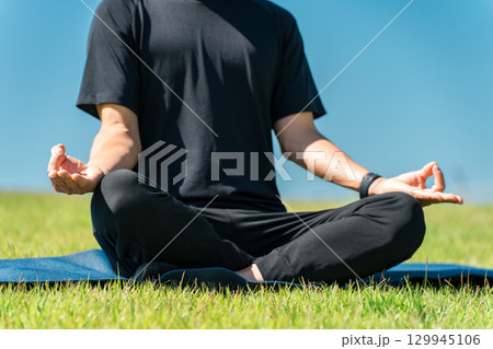 公園でヨガ・ピラティスをする男性(運動・瞑想・ワークアウト・ヨガ・スポーツ・ストレッチ) 公園でヨガ・ピラティスをする男性(運動・瞑想・ワークアウト・ヨガ・スポーツ・ストレッチ) 129945106