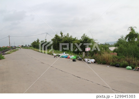 rural road in vietnam with people riding bicycles and motorbikes 129945303