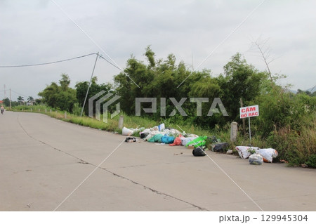 rural road in vietnam with people riding bicycles and motorbikes rural road in vietnam with people riding bicycles and motorbikes 129945304