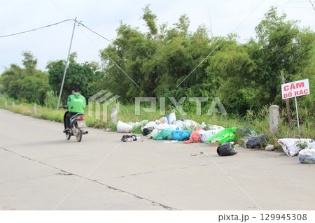 rural road in vietnam with people riding bicycles and motorbikes rural road in vietnam with people riding bicycles and motorbikes 129945308