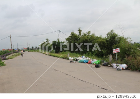rural road in vietnam with people riding bicycles and motorbikes rural road in vietnam with people riding bicycles and motorbikes 129945310