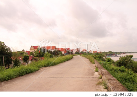 rural road in vietnam with people riding bicycles and motorbikes rural road in vietnam with people riding bicycles and motorbikes 129945329