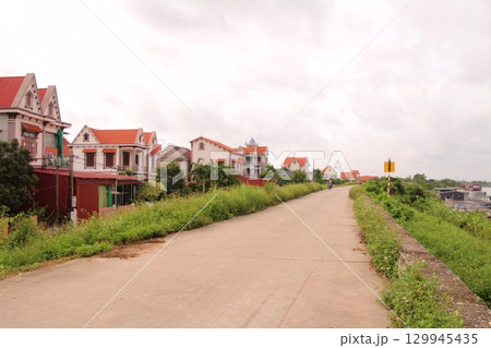 rural road in vietnam with people riding bicycles and motorbikes rural road in vietnam with people riding bicycles and motorbikes 129945435