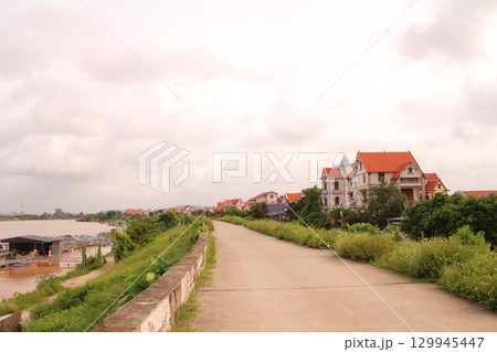 rural road in vietnam with people riding bicycles and motorbikes rural road in vietnam with people riding bicycles and motorbikes 129945447