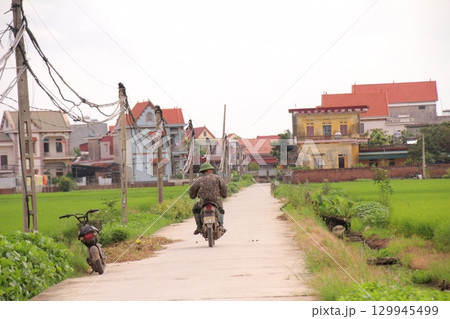 rural road in vietnam with people riding bicycles and motorbikes 129945499