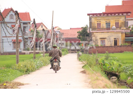 rural road in vietnam with people riding bicycles and motorbikes rural road in vietnam with people riding bicycles and motorbikes 129945500