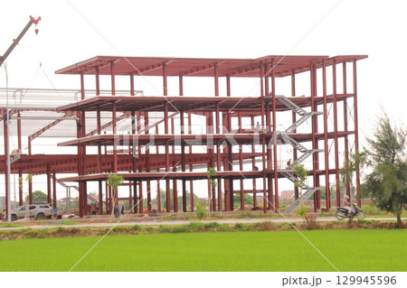 on construction site in vietnam. Construction workers. Machinery is digging the ground 129945596