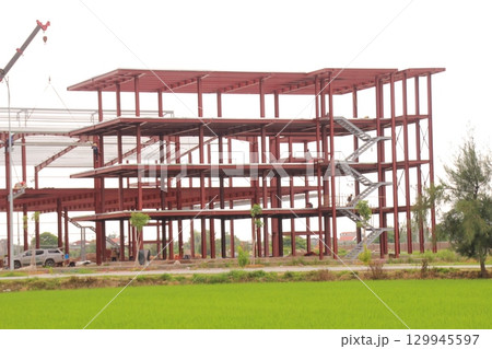 on construction site in vietnam. Construction workers. Machinery is digging the ground 129945597