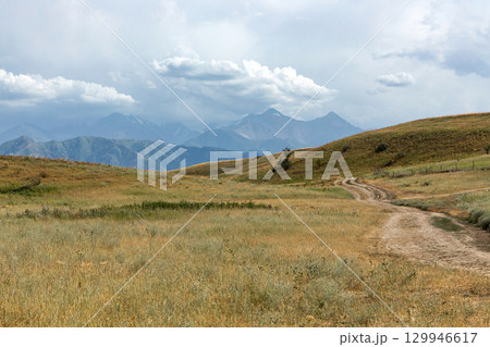 Rural road to mountains among the hills. Rural road to mountains among the hills. 129946617