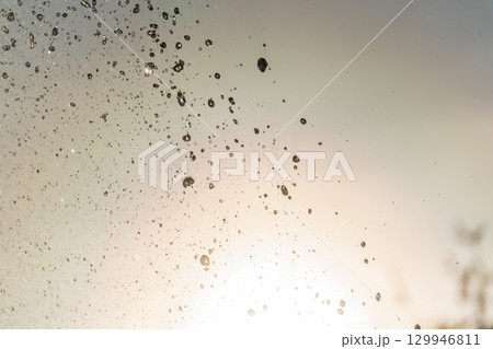 Splashes and jets of water against light background. 129946811