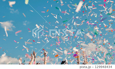 Graduating students gleefully tossing colorful confetti to mark their achievement and embrace new beginnings 129948434