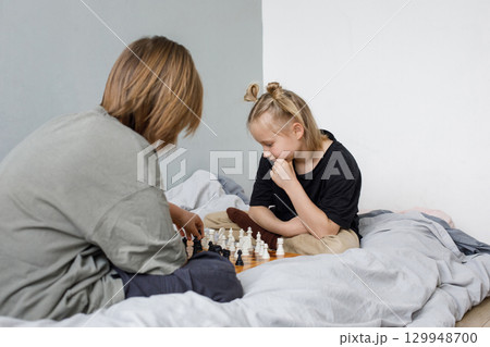 Concentrated boy and girl playing chess board game while thinking of move with knowledge Concentrated boy and girl playing chess board game while thinking of move with knowledge 129948700