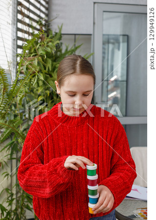 Cute child girl holding paint bottles after drawing on terrace 129949126