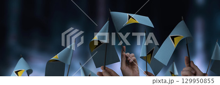 Saint Lucia flags in their hands on a blurred urban background Saint Lucia flags in their hands on a blurred urban background 129950855