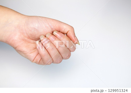 a woman's hand with long, natural nails forming a fist against a clean white background. natural nails empowerment fist isolated. long natural nails beauty symbol a woman's hand with long, natural nails forming a fist against a clean white background. natural nails empowerment fist isolated. long natural nails beauty symbol 129951324