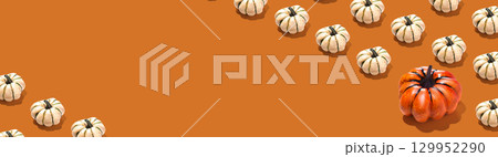 Horizontal banner with pumpkins pattern on orange background. Halloween concept copy space 129952290