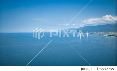 8月の終わりの富山県下新川海岸と洋上風力発電風車 129952759