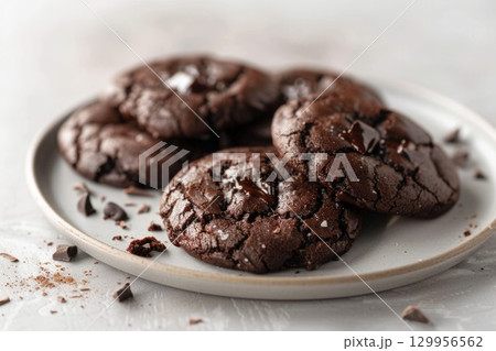 Close-up of melted chocolate cookies on white plate. Neural network AI generated 129956562