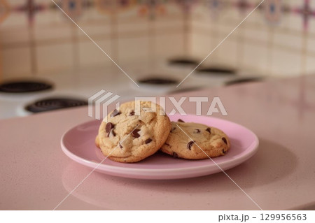 Chocolate chip cookies on pink plate in kitchen. Neural network AI generated 129956563