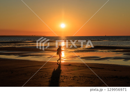 オーストラリア　夕焼けの美しいMindi Beachを歩く女性 129956971