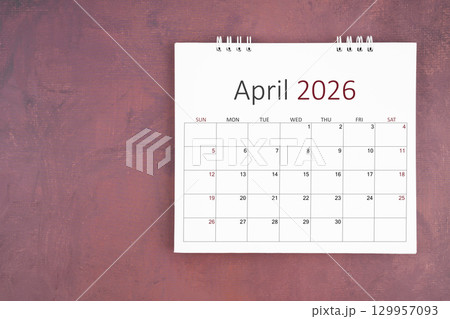 April 2026 desk calendar on red cement wall background. Page of annual monthly calendar for plan. 129957093