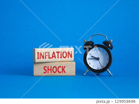 Inflation Shock symbol. Concept word Inflation Shock on wooden blocks. Beautiful blue background with alarm clock. Business and Inflation Shock concept. Copy space Inflation Shock symbol. Concept word Inflation Shock on wooden blocks. Beautiful blue background with alarm clock. Business and Inflation Shock concept. Copy space 129958696