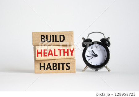 Healthy habits symbol. Concept word Build Healthy habits on wooden blocks with alarm clock. Beautiful white background. Healthy lifestyle and Healthy habits concept. Copy space Healthy habits symbol. Concept word Build Healthy habits on wooden blocks with alarm clock. Beautiful white background. Healthy lifestyle and Healthy habits concept. Copy space 129958723