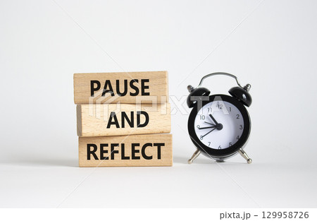 Pause and Reflect symbol. Concept words Pause and Reflect on wooden blocks. Beautiful white background with alarm clock. Business and Pause and Reflect concept. Copy space. 129958726