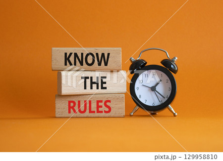 Know the rules symbol. Wooden blocks with words Know the rules. Beautiful orange background with alarm clock. Business and Know the rules concept. Copy space. 129958810