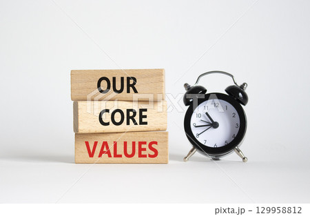 Our core values symbol. Concept words Our core values on wooden blocks. Beautiful white background with alarm clock. Business and Our core values concept. Copy space. 129958812