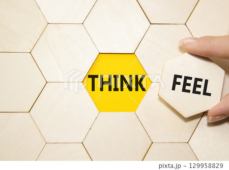 Think or Feel symbol. Concept word Think or Feel on wooden comb puzzle. Businessman hand. Beautiful yellow background. Business and Think or Feel concept. Copy space 129958829