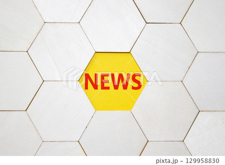 News symbol. Concept word News on wooden comb puzzle. Beautiful yellow background. Business and News concept. Copy space. 129958830