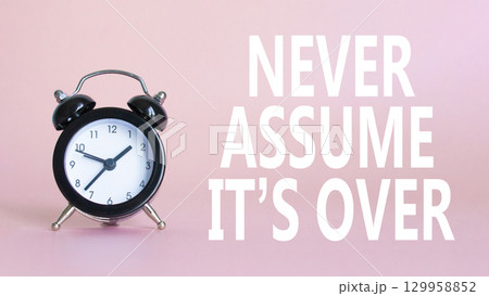 Never assume it is over symbol. Beautiful pink background with alarm clock. Business and Never assume it is over concept. Copy space. Never assume it is over symbol. Beautiful pink background with alarm clock. Business and Never assume it is over concept. Copy space. 129958852
