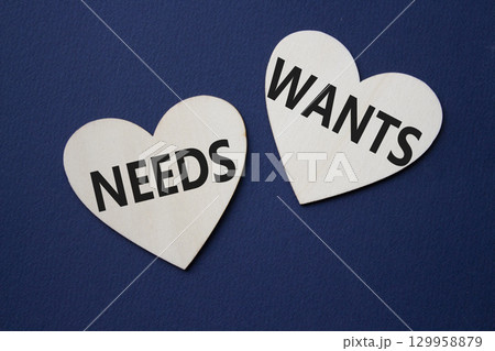 Wants and Needs symbol. Concept word Wants and Needs on wooden hearts. Beautiful deep blue background. Business and Wants and Needs concept. Copy space Wants and Needs symbol. Concept word Wants and Needs on wooden hearts. Beautiful deep blue background. Business and Wants and Needs concept. Copy space 129958879