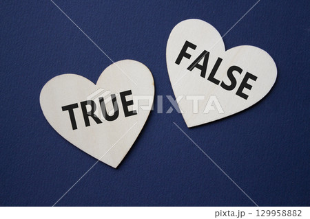 True or False symbol. Concept word True or False on wooden hearts. Beautiful deep blue background. Business and True or False concept. Copy space 129958882