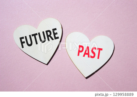 Future or Past symbol. Concept word Future or Past on wooden hearts. Beautiful pink background. Business and Future or Past concept. Copy space 129958889