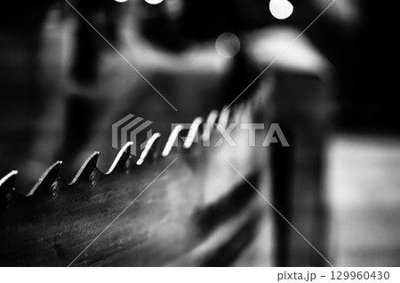 Close-up of wooden fence with metallic spikes captured at night in a serene outdoor setting 129960430