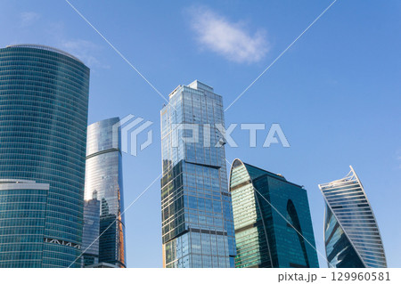 urban background, view of modern skyscrapers tops against blue sky urban background, view of modern skyscrapers tops against blue sky 129960581