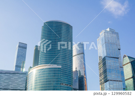 view of upper parts of modern skyscrapers against blue sky 129960582
