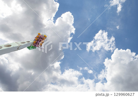 Fairground attraction and cloudy sky Fairground attraction and cloudy sky 129960627