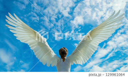 Person with angel wings against a cloudy sky. Person with angel wings against a cloudy sky. 129961064