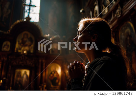 A woman is praying in a church 129961748