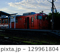 夕日を浴びて走るローカル線の電車 129961804